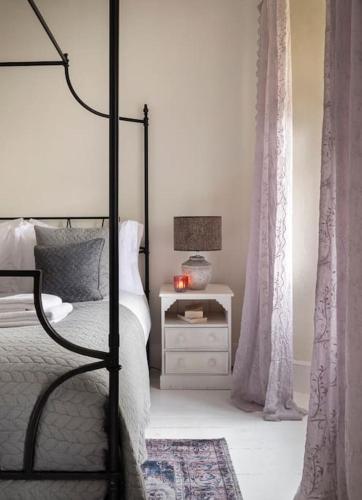 a bedroom with a bed and a table with a lamp at Shelbourne Georgian Townhouse in Kenmare