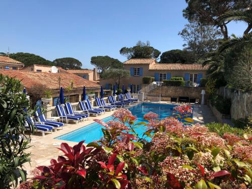 a pool with lounge chairs and a resort at Hôtel Jas Neuf in Sainte-Maxime