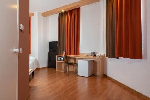 a hotel room with a desk and a bed and a room at Ibis Astana in Astana