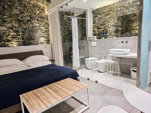 1 dormitorio con 1 cama y baño con lavamanos en ca' di sotto, en Riomaggiore