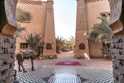 a building with a statue of a horse in a courtyard at Kasbah Hotel Xaluca Arfoud in Erfoud