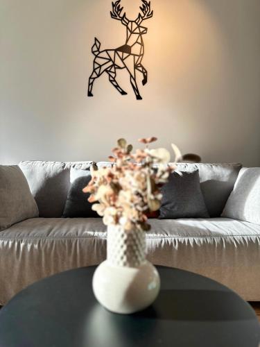 a vase on a table in front of a couch at Soca Valley Suites in Bovec
