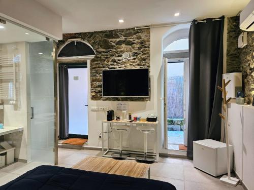 a bedroom with a tv on a stone wall at ca' di sotto in Riomaggiore