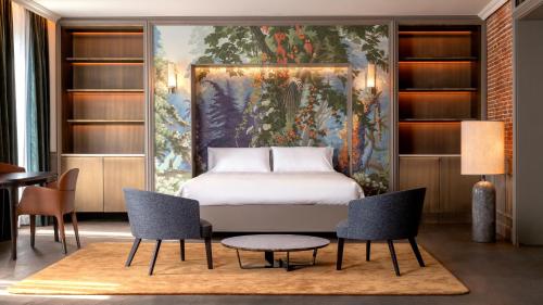 a bedroom with a bed and a painting on the wall at Casa Faraona Luxury Residences in Madrid