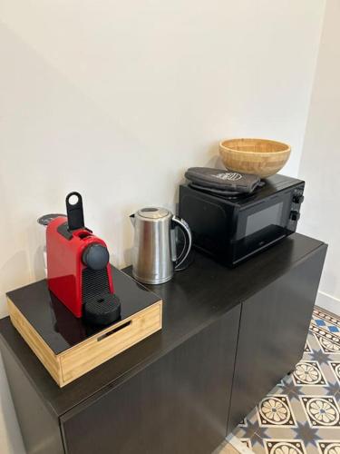 a counter with a toaster and a toaster and a microwave at Le Traveller - COSY FLAT Senlis in Senlis
