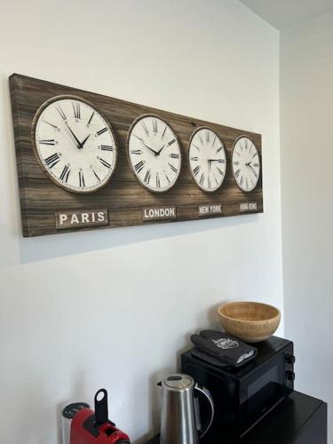 a row of clocks hanging on a wall at Le Traveller - COSY FLAT Senlis in Senlis