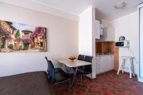 a room with a table and chairs and a kitchen at Mila & Aleksandr Apartments in Budva