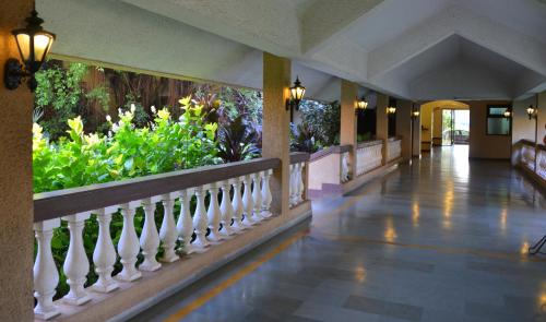 a hallway of a resort with a fence and plants at The Fern Kesarval Hotel & Spa, Verna Plateau - Goa in Verna