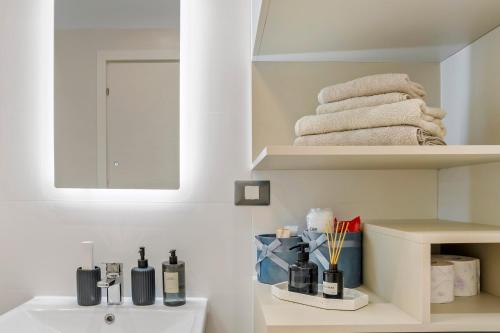 een badkamer met een wastafel, een spiegel en handdoeken bij My Place Residence in Voluntari