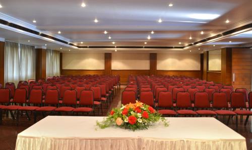 a banquet hall with red chairs and a table with flowers at The Fern Kesarval Hotel & Spa, Verna Plateau - Goa in Verna