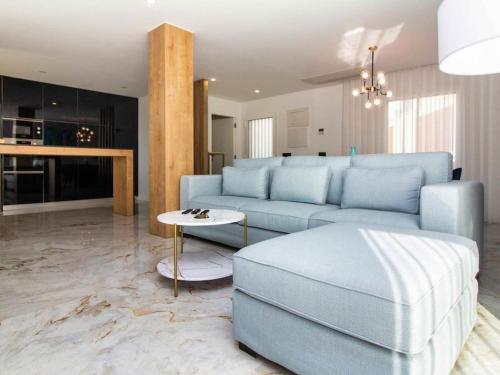 a living room with a blue couch and a table at Sea la Vie House by Stay ici in Albufeira