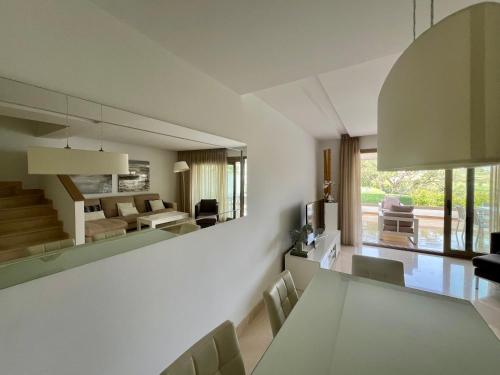 una sala da pranzo e un soggiorno con tavolo e sedie. di Splendide maison sur 4 étages située sur le golf de Cala de Mijas a La Cala de Mijas