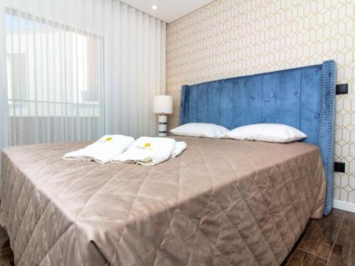 阿爾布費拉的住宿－Sea La Vie House - Privat Pool & Luxurious & Top View & Albufeira，一张带蓝色床头板和白色枕头的大床