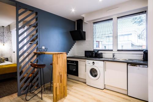 a kitchen with a washing machine and a washer and dryer at Homey Cute - Parking inclus - Proche Geneve in Annemasse