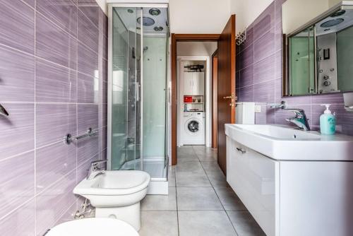 La salle de bains est pourvue de toilettes, d'un lavabo et d'une douche. dans l'établissement green oasis in milan - luxury appartment free wifi - Policlinico San Donato, à San Donato Milanese