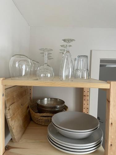 a shelf with glass jars and plates on it at La Canopée des Arbres, Anna in Ellezelles