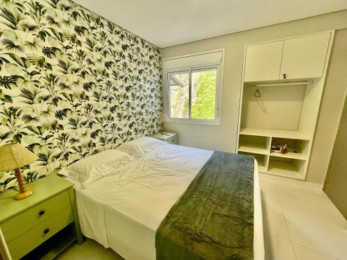 ein Schlafzimmer mit einem Bett und einer geblümten Tapete in der Unterkunft Camburizinho 3 suítes Beach Tenis in São Sebastião