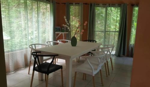 a dining room with a white table and chairs at Casa Palmera Cocles, 300m to the beach in Puerto Viejo