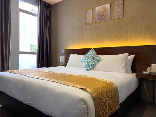 a large bed in a hotel room with a window at HSK Hotel Kuala Lumpur in Kuala Lumpur