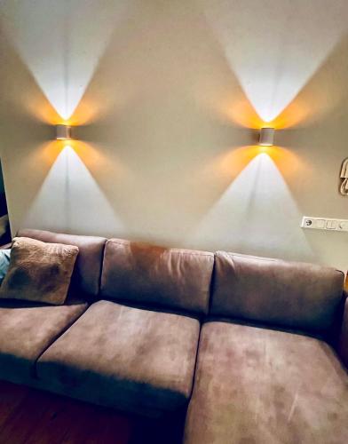 a living room with a couch and two lights on the wall at G10 Apartments in Akureyri