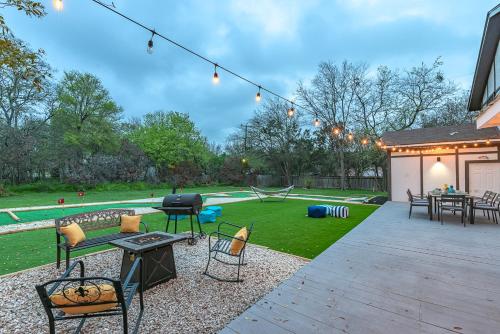 a backyard with a barbecue grill and a lawn at Pool, Gameroom & Minigolf Enchanting Texas Home in San Antonio