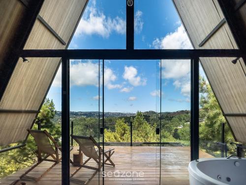 a bathroom with a large window and a tub at Chales Naturale - Campos do Jordão - CNA in Campos do Jordão