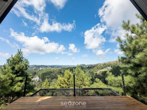 a view from the balcony of a house with a blue sky at Chales Naturale - Campos do Jordão - CNA in Campos do Jordão