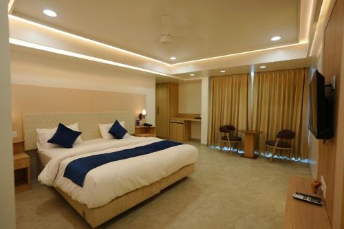 a hotel room with a large bed and a television at Hotel 6 Seasons, Koregoan Park, Pune in Pune
