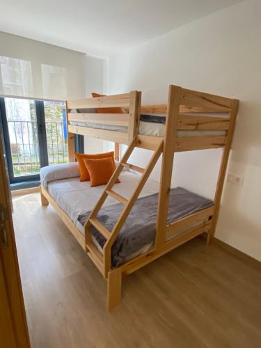 a bunk bed with a ladder in a room at Apartamentos Luisa in Santiago de Compostela