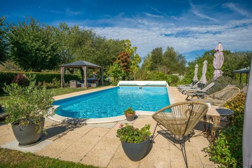 uma piscina num quintal com mesa e cadeiras em La Sellerie at No 17 em Le Dorat