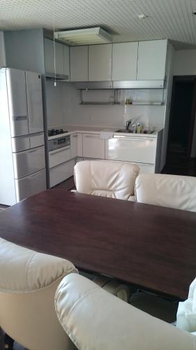 a kitchen with a wooden table and white cabinets at minato hotel in Kyoto