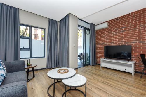 a living room with a brick wall at Easy Stay - The Vantage Rosebank in Johannesburg