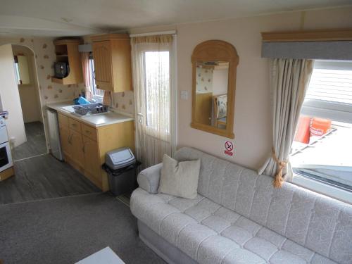 a living room with a couch and a kitchen at 8 Berth on Sealands Everglade III in Ingoldmells