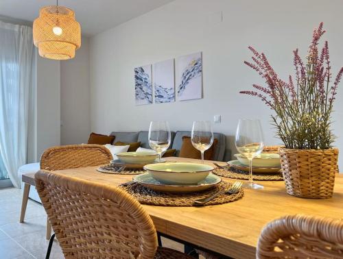 a dining room table with plates and wine glasses at Apartamento La Sal Cubelles in Cubelles