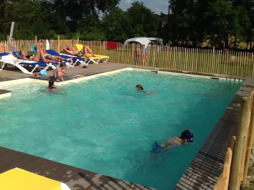 a group of people swimming in a swimming pool at Les Savonniers in Beauregard