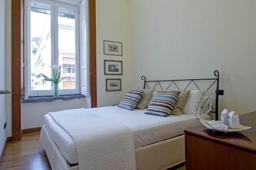 een slaapkamer met een bed met kussens en een raam bij Starhost - Casa Vela Exclusive Apartment - Amalfi Coast in Maiori