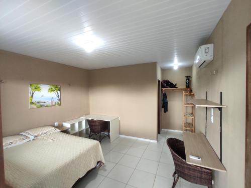 a bedroom with a bed and a table and chairs at Taíba Downwind House in São Gonçalo do Amarante