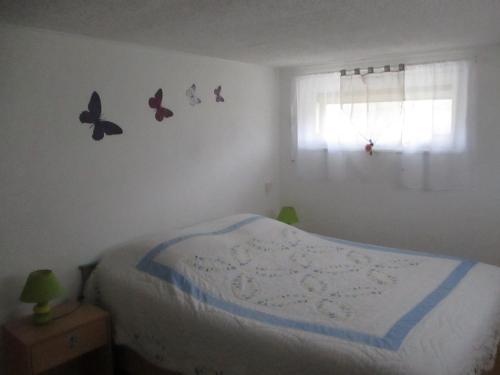 een slaapkamer met een bed met vlinders aan de muur bij le gite fleuri in Abbeville