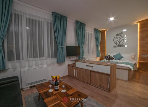 a living room with a bed and a room with a table at Хотел Терра Роза in Karlovo