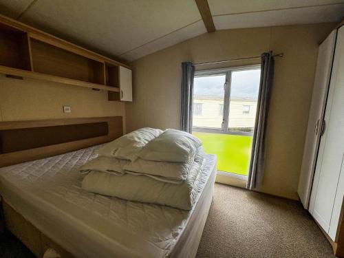 a bedroom with a bed and a large window at Lovely 6 Berth Caravan With Free Wifi At Sand Le Mere, Yorkshire Ref 71011c in Tunstall