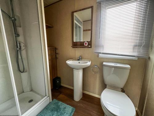 a bathroom with a toilet and a sink and a shower at Lovely 6 Berth Caravan With Wi-fi At Sand Le Mere In Yorkshire Ref 71091td in Tunstall