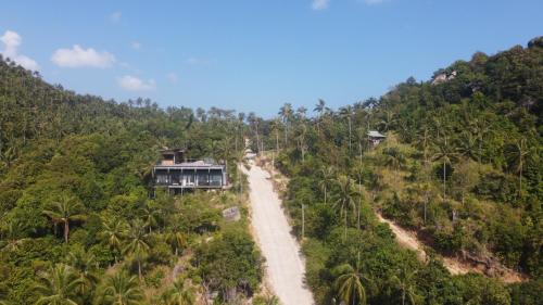 a house on a hill with a dirt road at Ozone Hill Panoramic Residence Thong Nai Pan Beach in Thong Nai Pan Noi