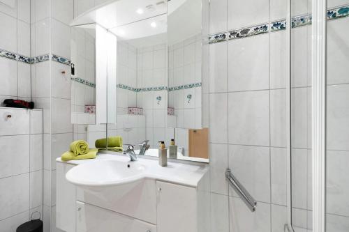 ein weißes Bad mit einem Waschbecken und einer Dusche in der Unterkunft Haus Beate Klein in Kröv