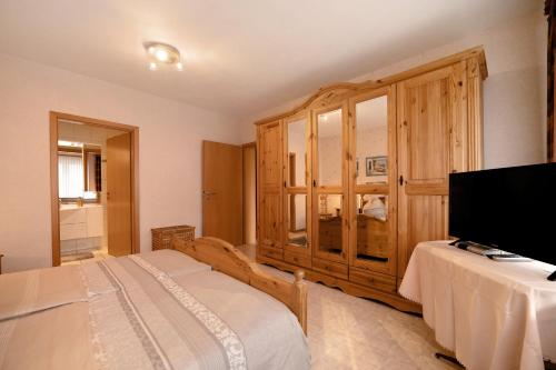 ein Schlafzimmer mit einem Bett und einem großen Holzschrank in der Unterkunft Haus Beate Klein in Kröv