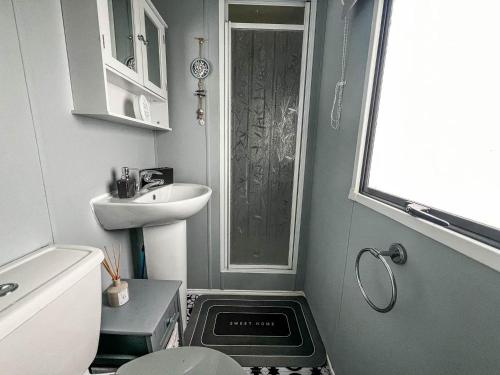 Baño pequeño con aseo y lavamanos en Homely Caravan At Sand Le Mere Holiday Park Ref 71018n, en Tunstall