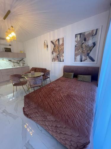 um quarto com uma cama grande e uma mesa em Apartament Słoneczny Piasek- A 147 z klimatyzacją- Solny Resort em Colberga