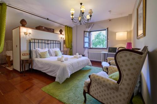 1 dormitorio con 1 cama blanca y 1 silla en The Basque Experience by Fidalsa, en Ochandiano