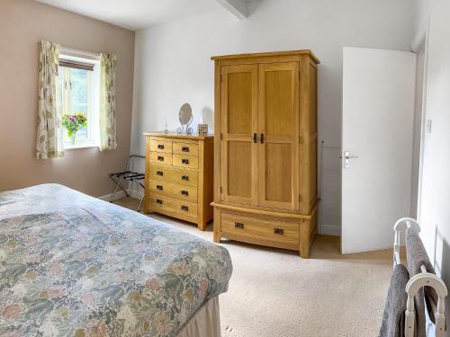 a bedroom with a wooden cabinet and a dresser at Chaplin in Legbourne