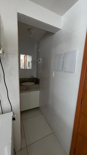 uma pequena casa de banho branca com um lavatório e um espelho. em Israel flat tambau 106 em João Pessoa
