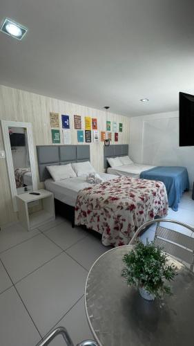 a hotel room with two beds and a table at Israel flat tambau 106 in João Pessoa